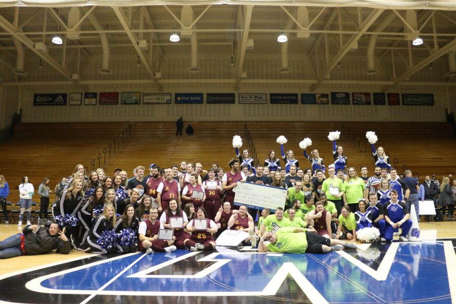 The special olympics athletes and students in Dr. Coles class stand with the check following the 2019 Rally for the Rapids game